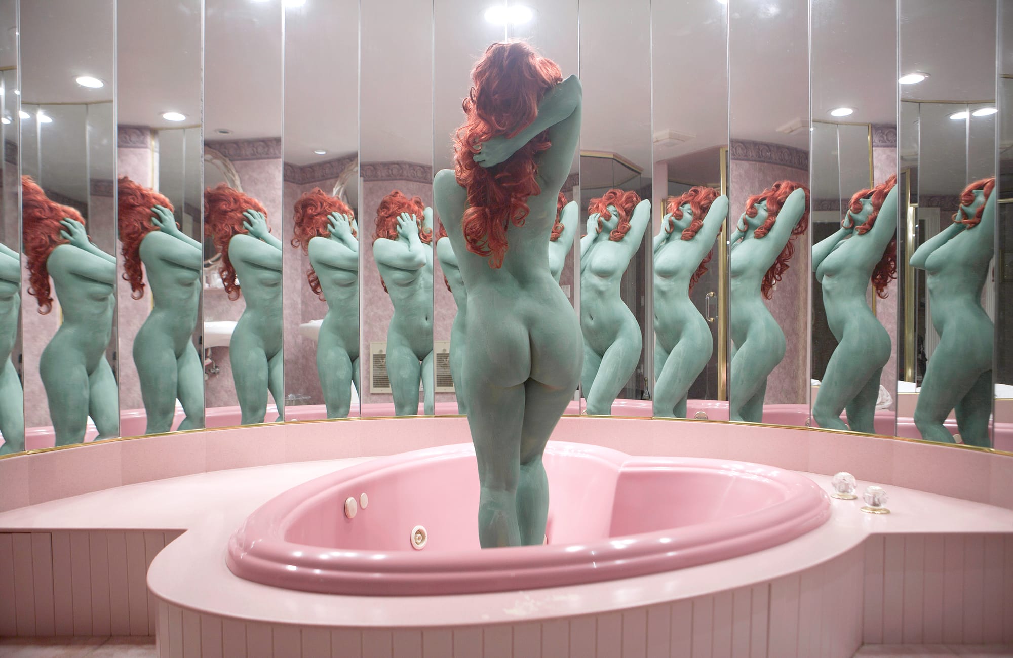  A self-portrait of Juno Calypso in which she stands nude, her body painted green, in a room of mirrors