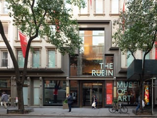 An exterior shot of the Rubin Museum of Art with the museum's name in the windows