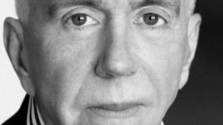 A black and white photo closely cropped to the face of a man who looks directly at the camera