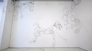 Wire sculpture of galloping horses suspended across a white gallery wall in an SVA MFA exhibition.