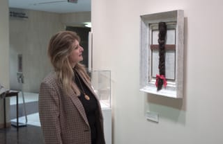 Celia Wells, a guest to the federal courthouse in Brooklyn, is pictured admiring an artwork by Natsuki Takauji, created using found objects donated to Materials for the Arts