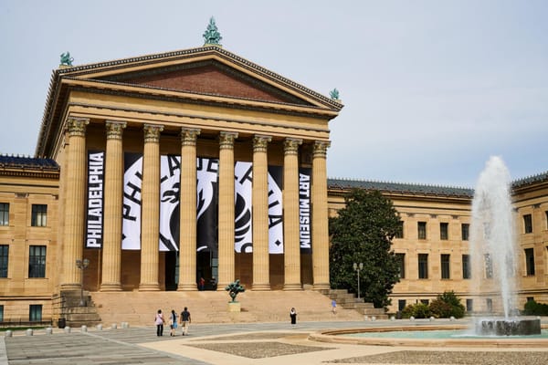 The Philadelphia Art Museum building with large black-and-white banners displaying its new logo and name hanging between the front columns.