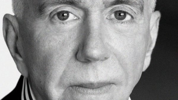 A black and white photo closely cropped to the face of a man who looks directly at the camera