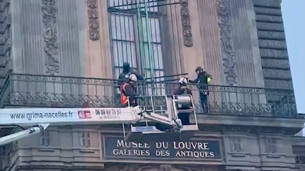 Workers using a hoist truck to install a new security grille over a balcony window at the Musée du Louvre following the October jewel theft.