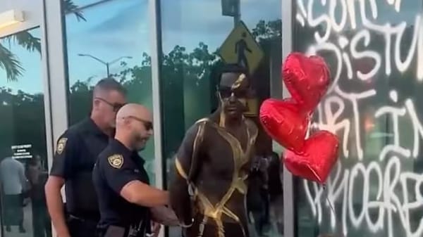 Cropped screenshot from an Instagram video showing chalk spray writing on a glass window at the Miami Beach Convention Center during Art Basel in Miami Beach.