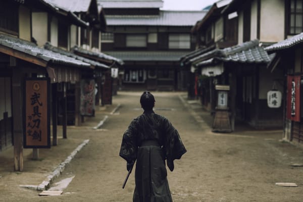 Figure in samurai-era clothing walking through a historic Japanese street, illustrating a Japan Samurai cultural itinerary.