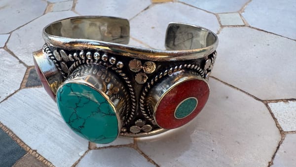 Amazigh silver cuff bracelet with turquoise and coral stones, a traditional North African jewelry style often linked to cultural heritage.