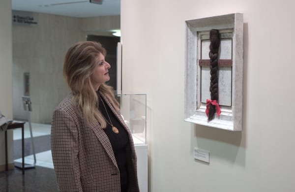 Celia Wells, a guest to the federal courthouse in Brooklyn, is pictured admiring an artwork by Natsuki Takauji, created using found objects donated to Materials for the Arts